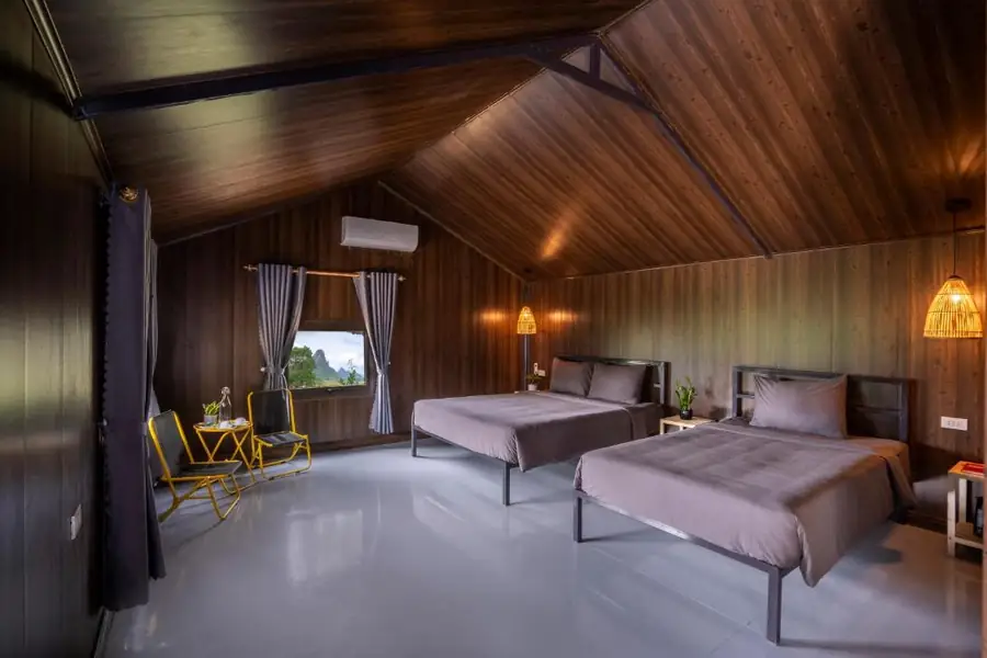 Phòng ngủ trong nhà phao: hai giường, điều hòa, cửa sổ nhìn ra núi đá